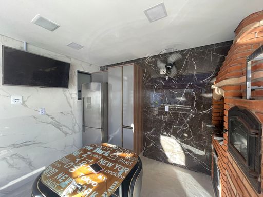Espaço gourmet com churrasqueira e forno de pizza.