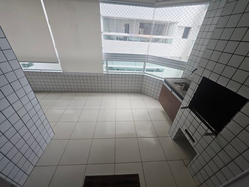 Sacada gourmet envidraçada com churrasqueira a carvão.