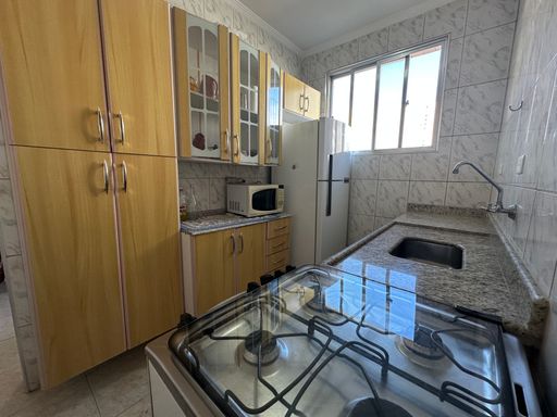 Cozinha com uma, pia, gabinete embutido, fogão e armários.