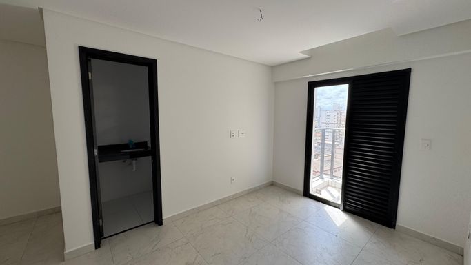 Suíte bem iluminada com uma sacada.