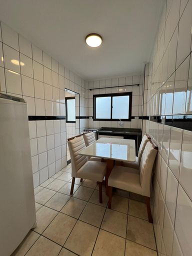 Cozinha espaçosa com uma pia, gabinete, fogão, geladeira e mesa para 04 pessoas.