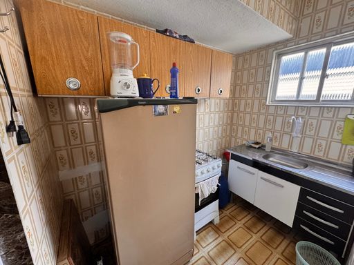 Cozinha com uma pia, fogão e geladeira.