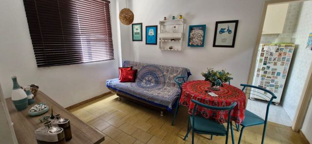 Sala bem iluminada e mobiliada com um ventilador de teto.