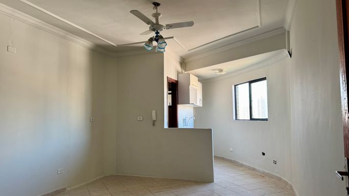 Sala living bem iluminado com ventilador de teto.