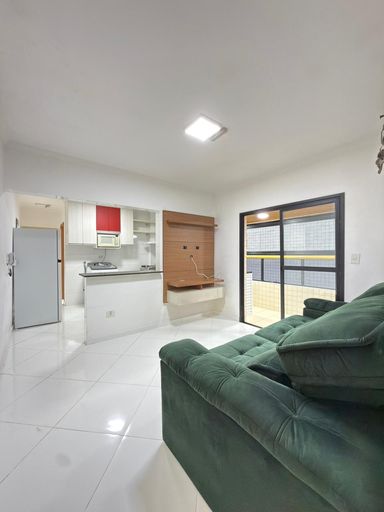 Sala bem iluminada com um sofá e sacada.