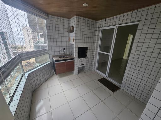 Sacada gourmet envidraçada com churrasqueira a carvão.