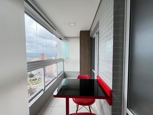 Sacada gourmet envidraçada com vista para o mar.