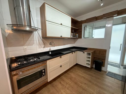 Cozinha americana planejada com uma geladeira Inox de duas portas.