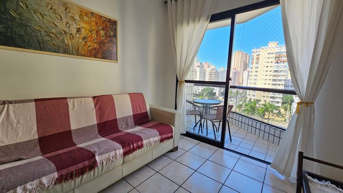 Sala de 2 ambientes com muita iluminação natural e um sofá.