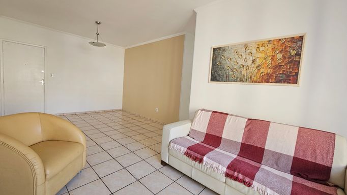 Sala de 2 ambientes com muita iluminação natural e um sofá.