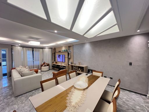 Sala ampla de 2 ambientes com teto rebaixado em gesso com iluminação em LED.