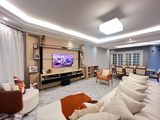 Sala ampla de 2 ambientes com teto rebaixado em gesso com iluminação em LED.