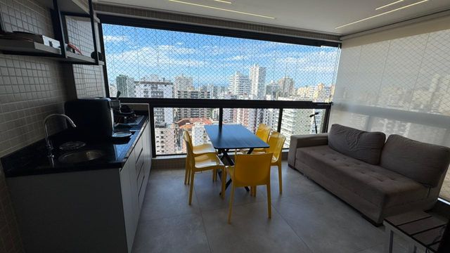 Sacada gourmet envidraçada com vista para o mar.