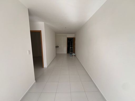 Sala de 2 ambientes com paredes brancas e iluminação natural.