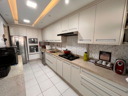 Cozinha com armários planejados e teto rebaixado em gesso com iluminação em LED.
