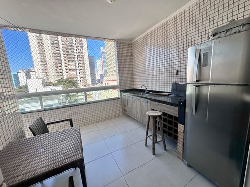 Sacada gourmet em L com geladeira e vista livre.