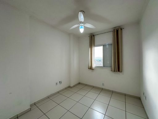 Dormitório bem iluminado com ventilador de teto.