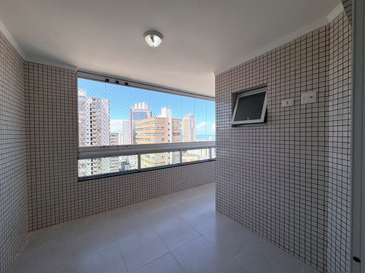 Sacada gourmet envidraçada com vista para o mar.