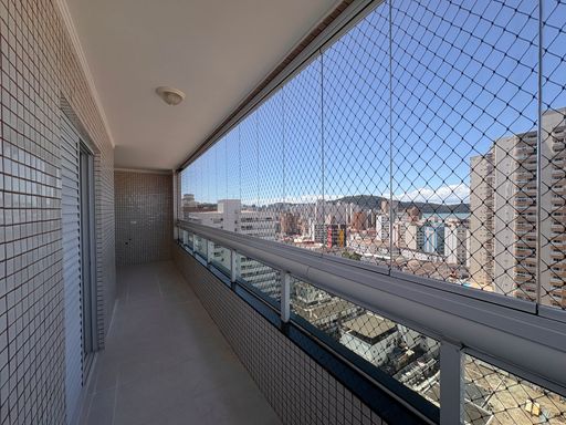 Sacada gourmet envidraçada com vista para o mar.