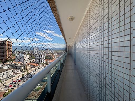 Sacada gourmet envidraçada com vista para o mar.