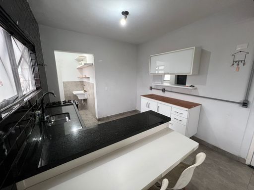 Cozinha americana muito bem iluminada com armários.