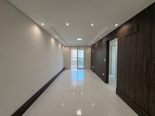 Sala ampla de 2 ambientes com teto rebaixado em gesso com iluminação em LED e parede espelhada.