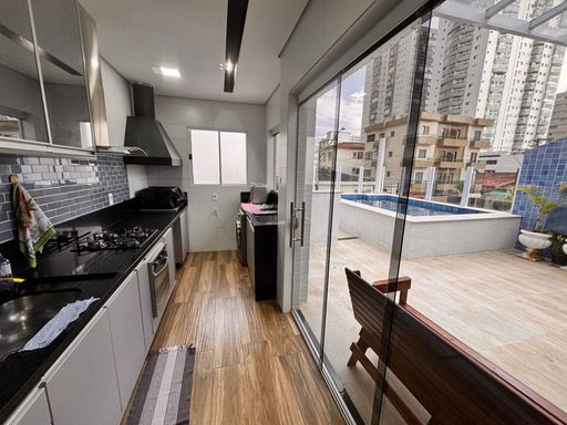 Cozinha integrada à piscina, completamente planejada, com fogão, coifa e geladeira.