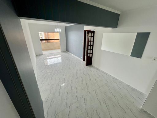 Sala bem iluminada de 3 ambientes com uma sacada envidraçada.