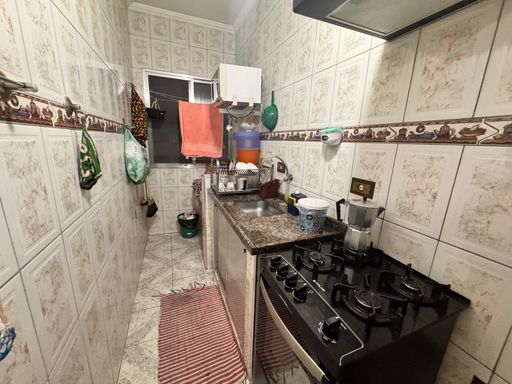 Cozinha com pia, gabinete e fogão e ventilador de teto.
