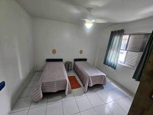 Dormitório amplo e bem iluminado com um ventilador de teto.