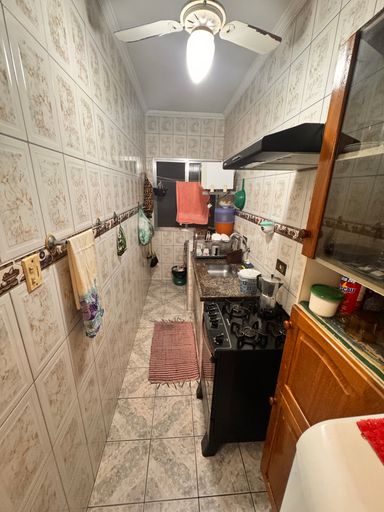 Cozinha com pia, gabinete e fogão e ventilador de teto.
