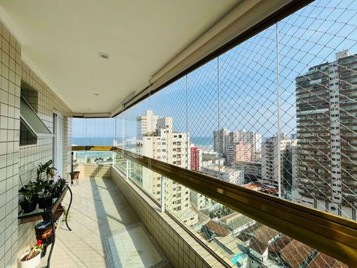 Sacada gourmet envidraçada com vista para o mar.