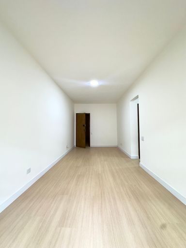 Sala ampla bem iluminada de dois ambientes com uma sacada.