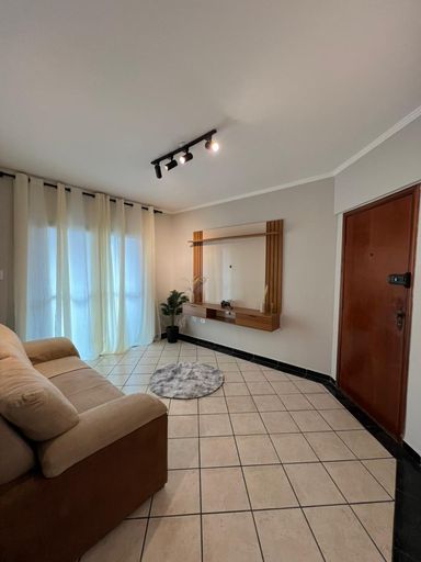 Sala ampla e bem iluminada com um sofá e painel de TV.