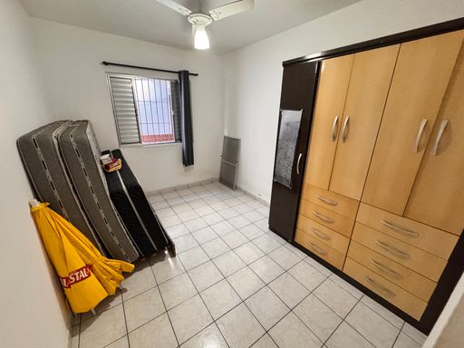 Dormitório muito bem iluminado com uma guarda-roupa e ventilador de teto.