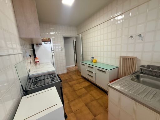 Cozinha com armários e uma geladeira branca.