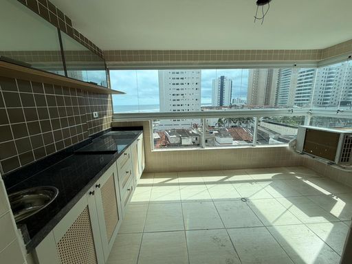 Sacada gourmet envidraçada com vista para o mar.