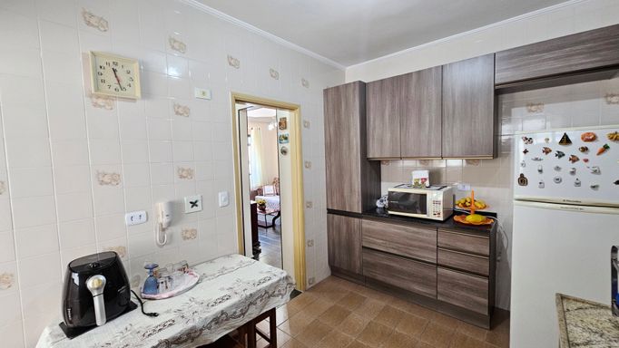 Cozinha com armários e uma geladeira.