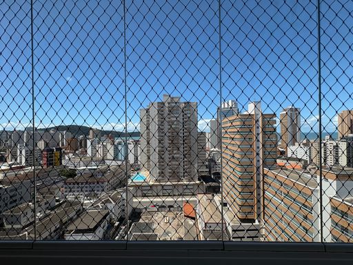 Sacada gourmet envidraçada com vista para o mar.