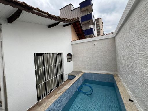 Quintal com uma piscina e churrasqueira.
