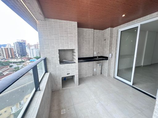 Sacada gourmet com vista livre e uma churrasqueira a carvão.