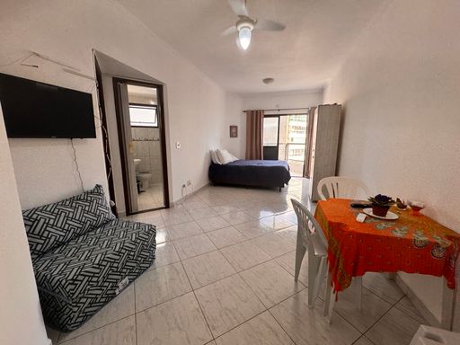 Sala living ampla e bem iluminada com uma sacada e ventilador de teto.