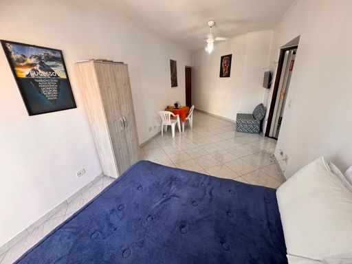 Sala living ampla e bem iluminada com uma sacada e ventilador de teto.