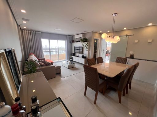 Sala ampla de 02 ambientes com sofá, mesa de jantar para seis pessoas, ar-condicionado e acesso a sacada gourmet.