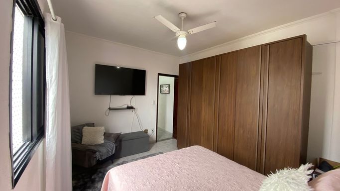 Dormitório bem iluminado com um ventilador de teto.