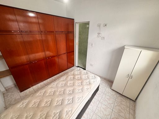 Dormitório bem iluminado com ar-condicionado.