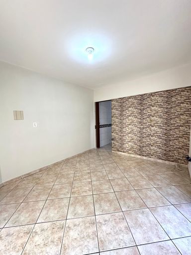 Sala bem iluminada com uma sacada privativa.