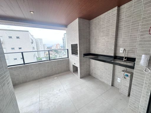 Sacada gourmet com vista livre e uma churrasqueira a carvão.