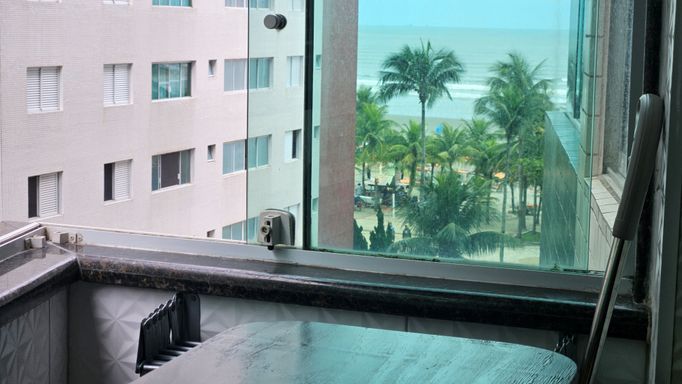 Sacada envidraçada com vista para o mar.
