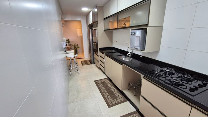 Cozinha americana com armários planejados.